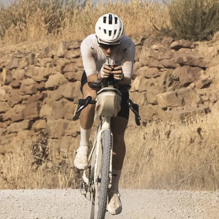 Jakob riding a loaded gravel bike on a dusty road